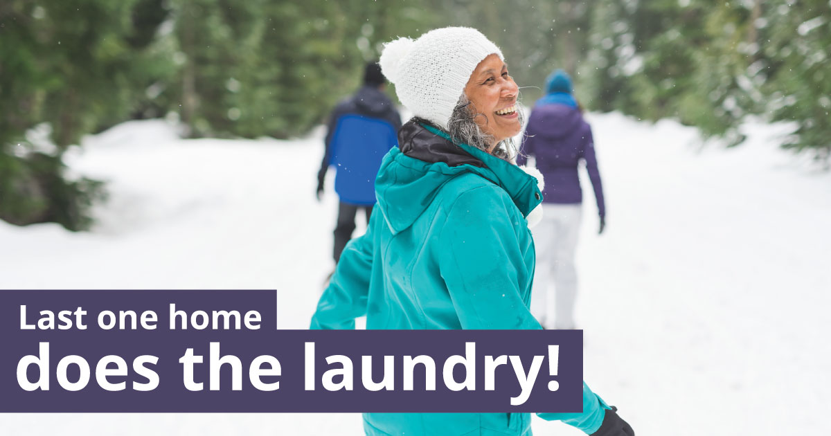 A woman walking in the snow looks behind her. Text reads: Last one home does the laundry!