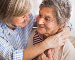 A woman hugs an older woman