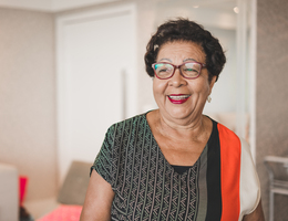 A woman wearing glasses and smiling.