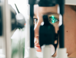 A close-up photo of someone’s eye being scanned during an exam.